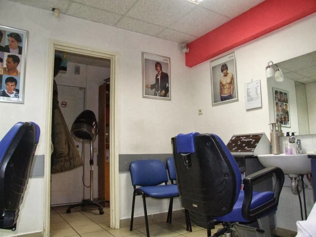 Interiorul salonului, cu scaune albastre și oglinzi